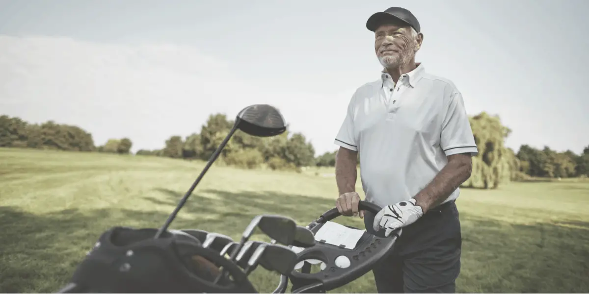 senior golfer push golf bag on golf push cart