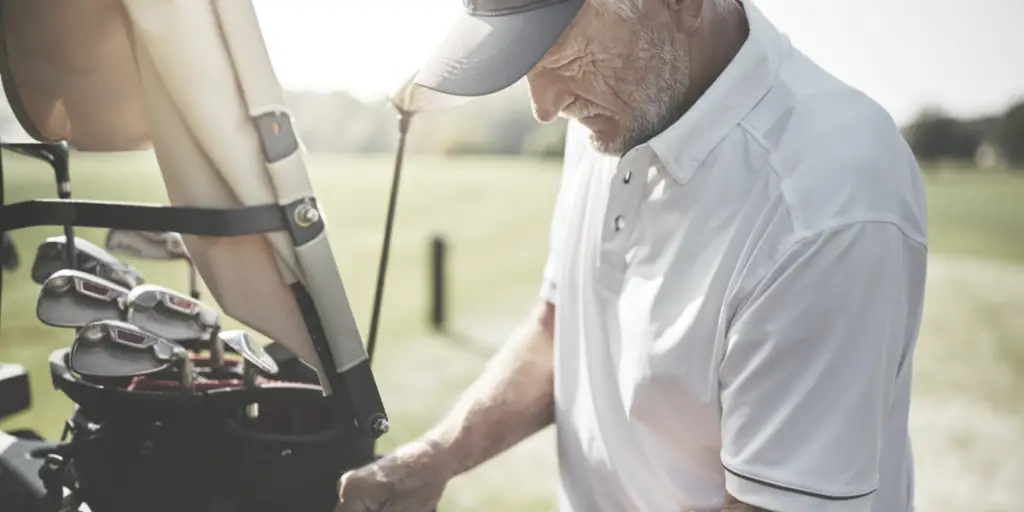 senior golfer with golf clubs on a cart