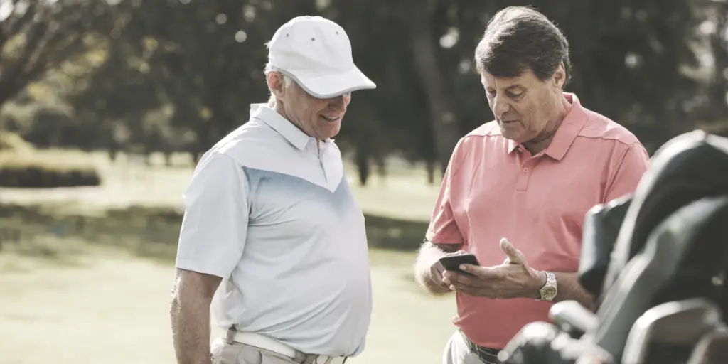 two golfers looking at a handheld device