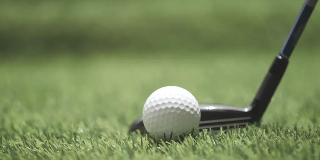 hybrid golf club sitting behind ball in fairway