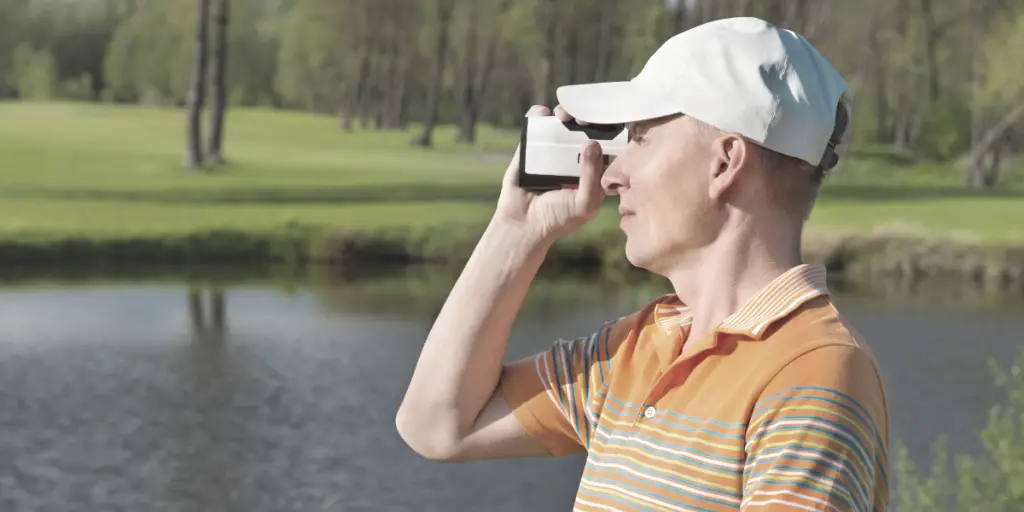 man looking through golf rangefinder